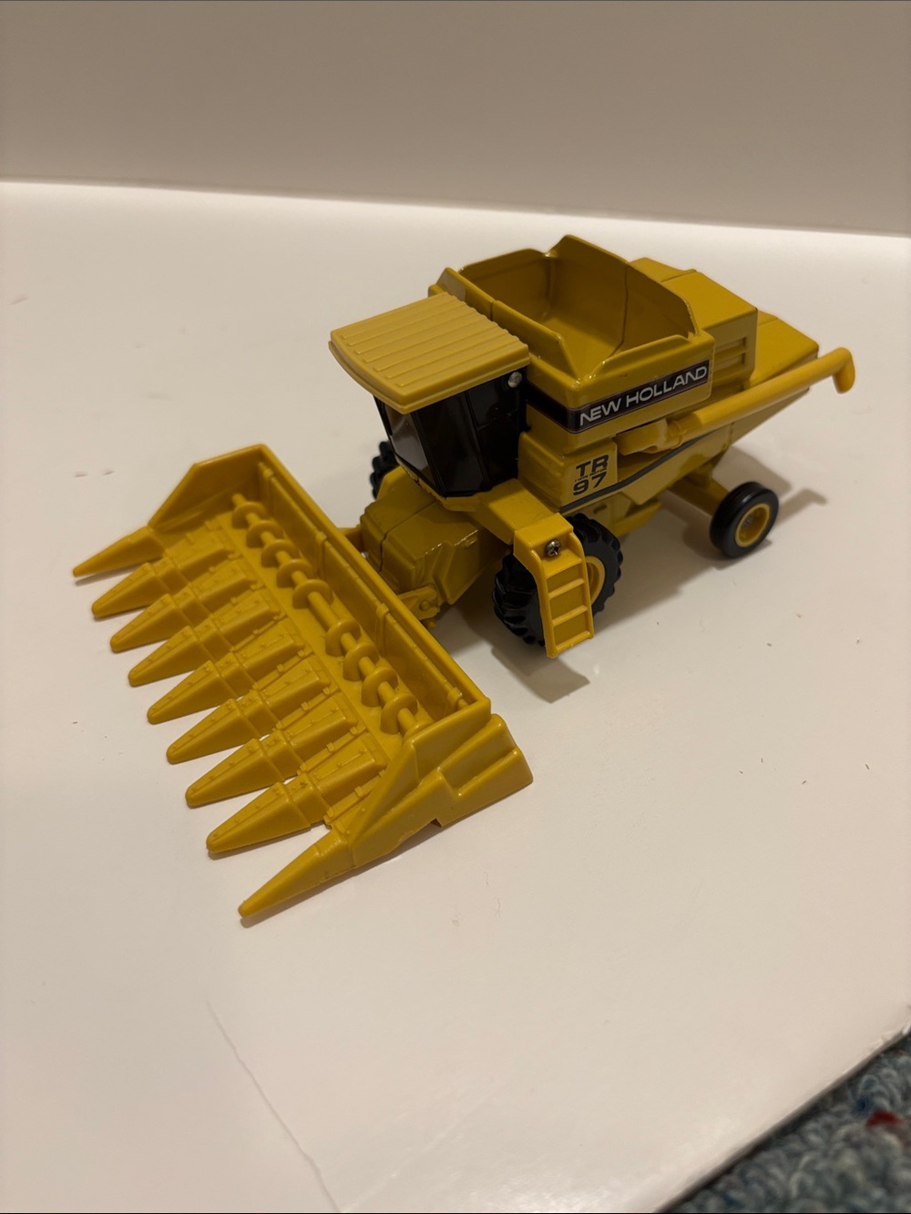 Ertl New Holland TR 97 combine with corn and wheat heads. 1/64 scale.